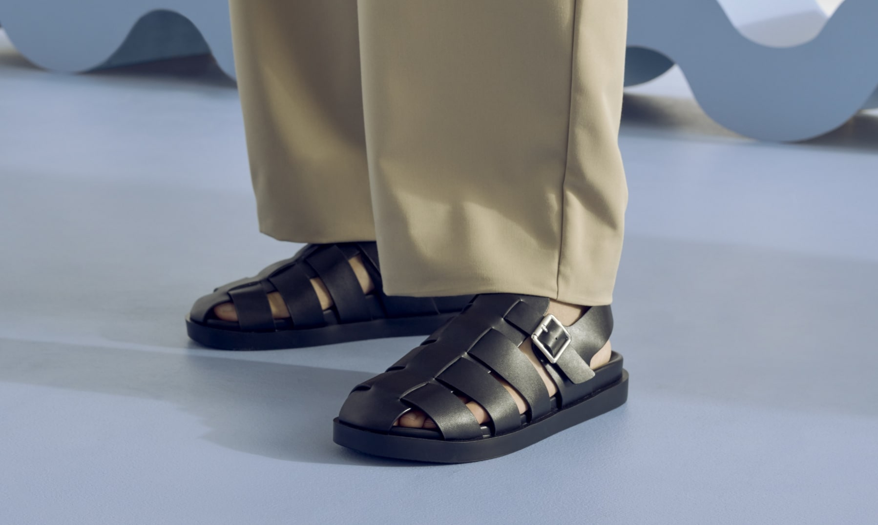Stacy Adams sandals featuring the Montego in black on a light blue floor.