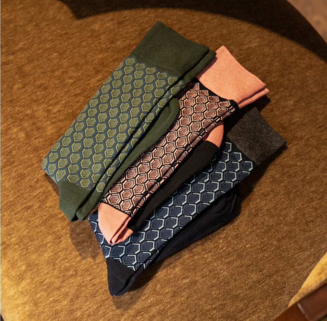 Shop Stacy Adams Socks featuring a variety of Colorful Hexagon Men's Crew Dress Socks on a brown backdrop.