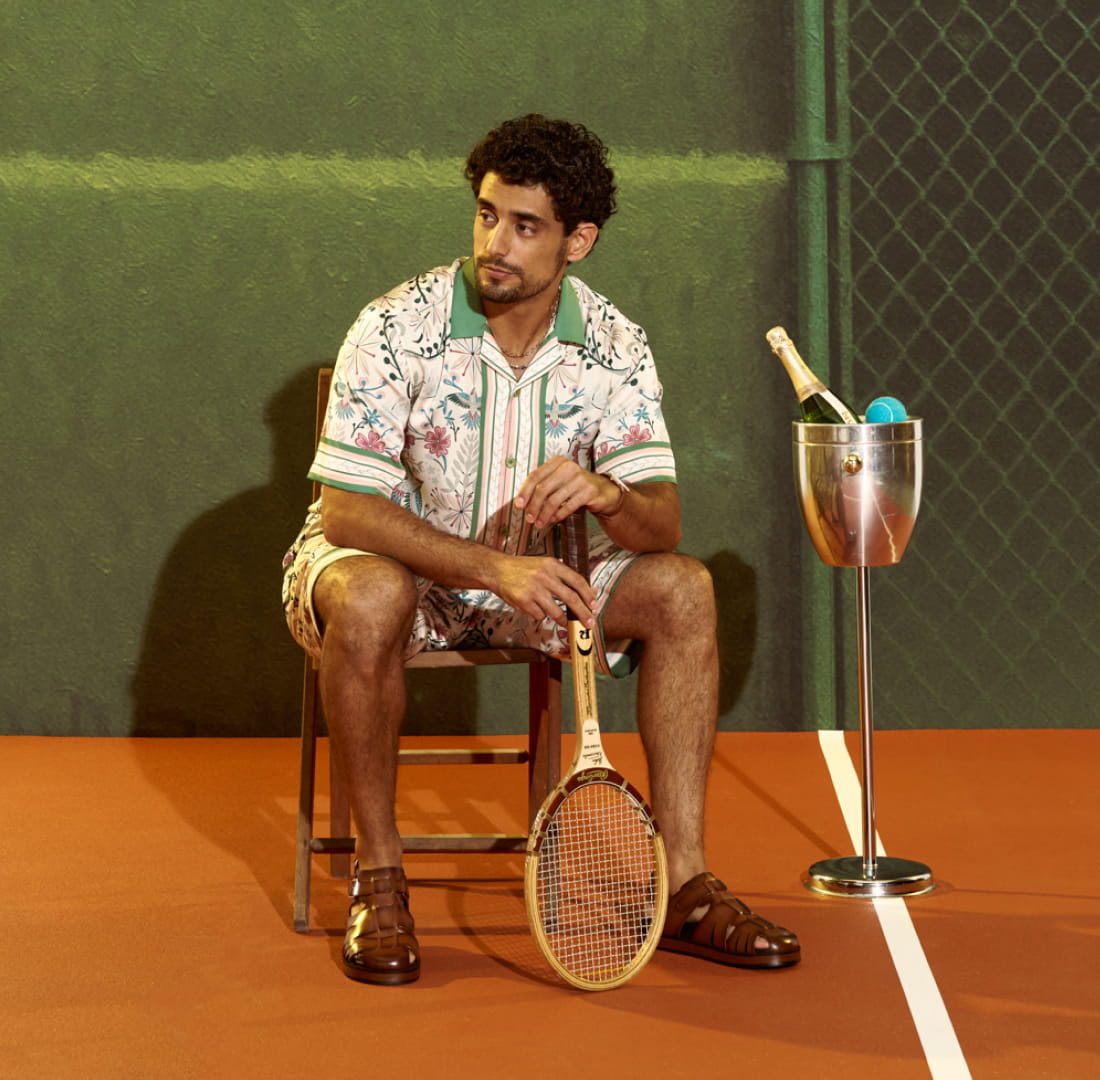 Shop Stacy Adams casual wear featuring a man sitting in a folding chair on a pickleball court.