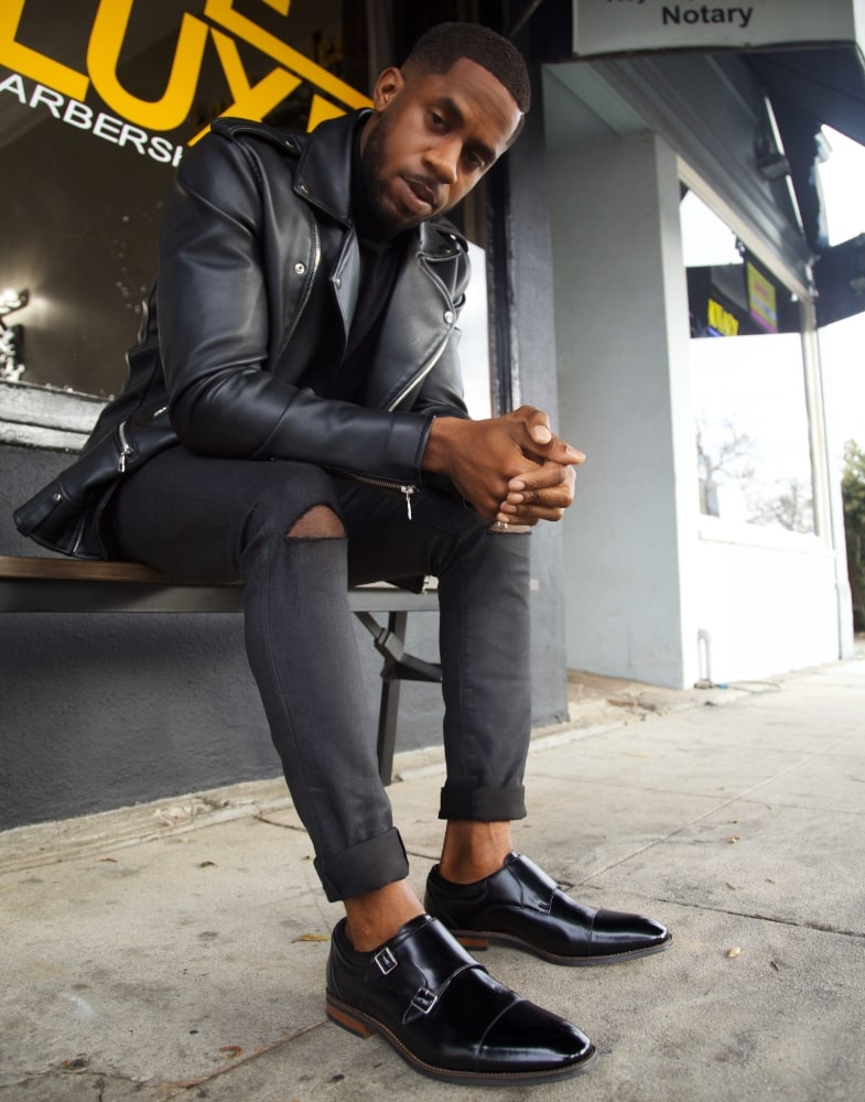 Image of social media influencer Chidi Ezemma wearing the Bayne Cap Toe Double Monk while sitting on a bench outside.