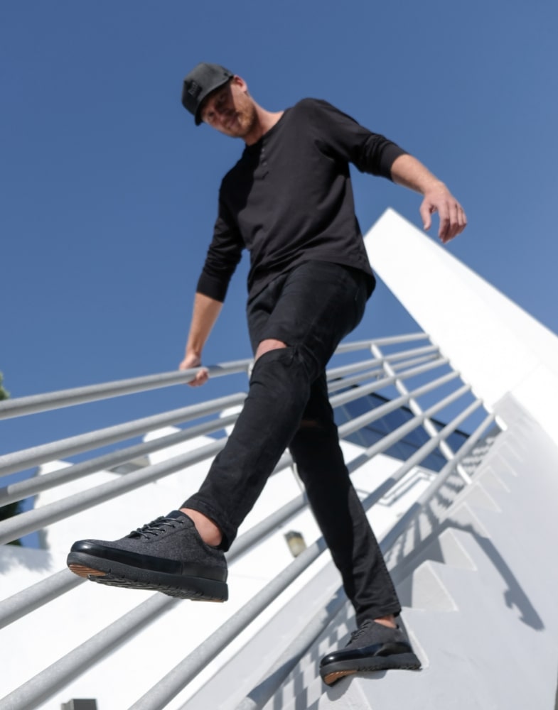 Image of social media influencer Drew Mellon walking down steps outside in the Hal Moc Toe Lace Up in Charcoal.