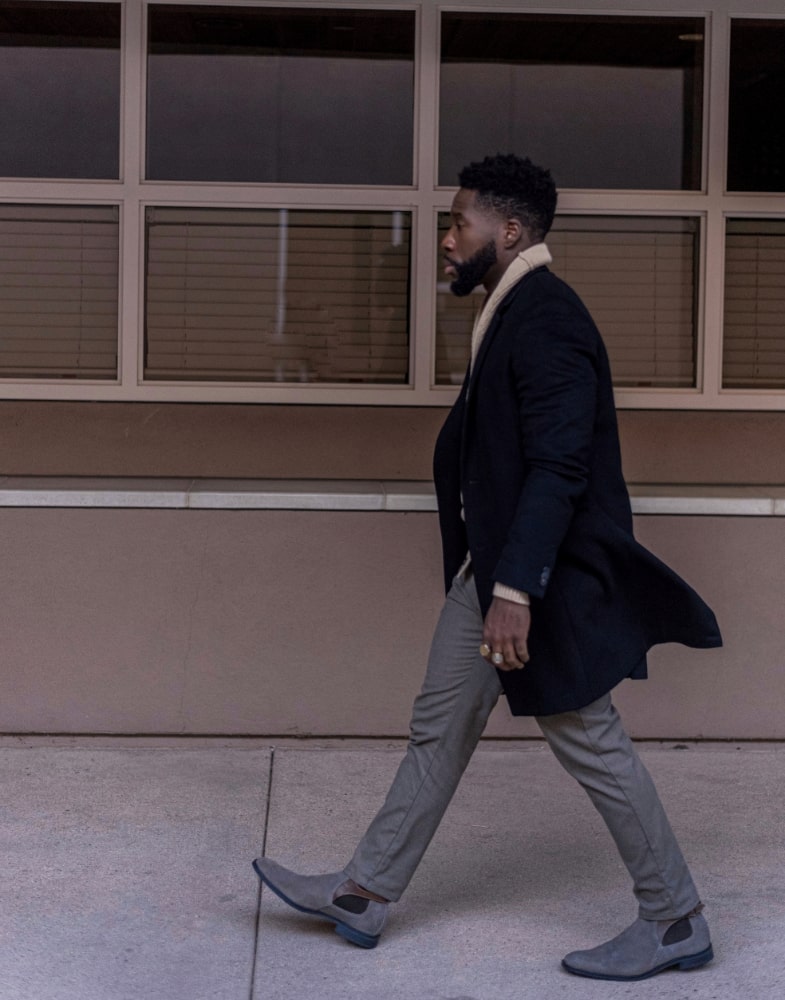 Image of social media influencer East Angles walking down the street in the Roane Plain Toe Chelsea Buckle Boot in Gray Suede.