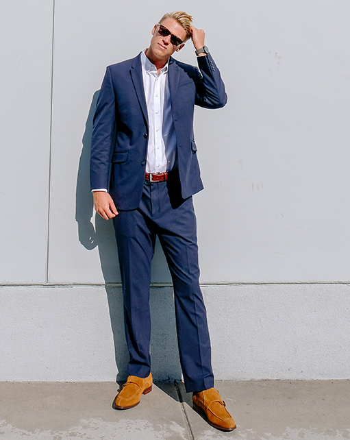 Image of social media influencer Drew Mellon from the duo "Beach Byrds" wearing the Eli Plain Toe Oxford in Cream while sitting on steps. 