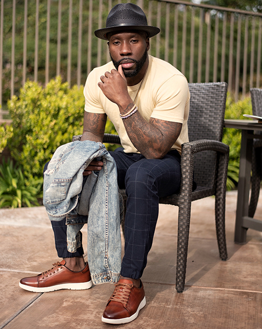 Image of social media influencer East Angles sitting down wearing the Hawkins Cap Toe Lace Up in Cognac while in Huntington Beach, California.