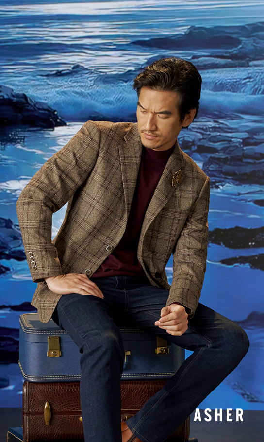 Men's Casual Wear category. Image features a man sitting on a stack of vintage trunks in a plaid blazer