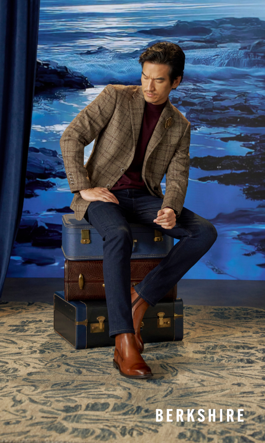 Men's Newest Shoes category. Image features a mean wearing the Berkshire Cap Toe Side Zip Boot in Brandy sitting on suitcases.