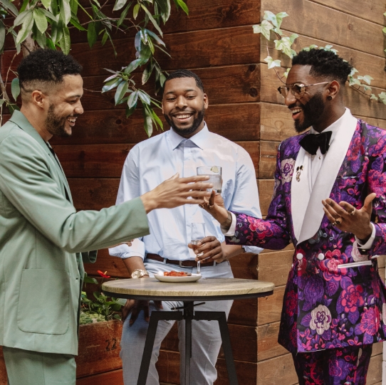 "What To Wear For A Wedding: Outfits For Men. The featured image shows three men in wedding attire.