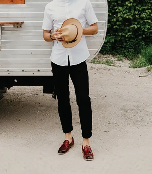 The featured image is of a model wearing a white oxford shirt and the Tazewell Plain Toe Tassel Slip On in Brick. 