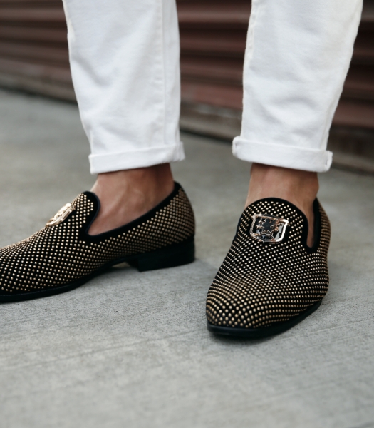 The featured image is of a model wearing the Swagger Studded Slip On in Black and Gold. .