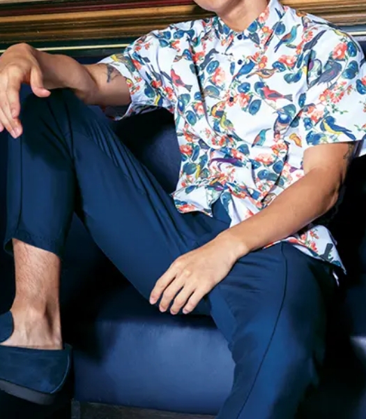 The featured image is a man sitting on a couch wearing a floral shirt, hat, and dress pants.