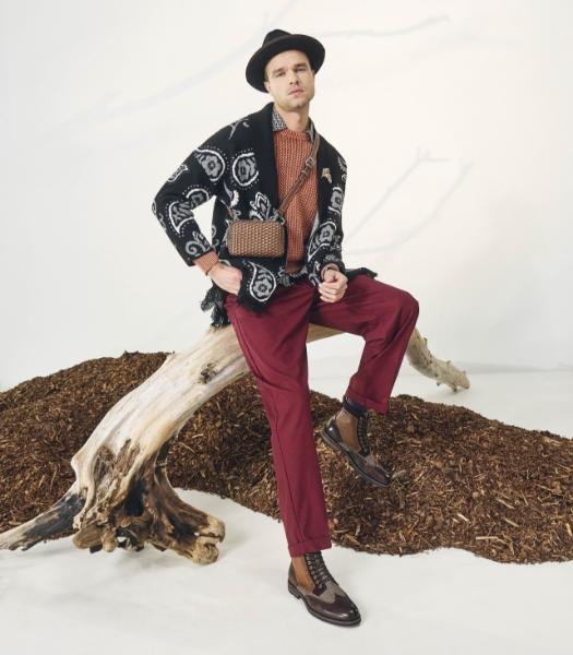 The featured image is a model sitting on a branch wearing the Oswyn Wingtip Lace Up Boot in Brown Multi. 