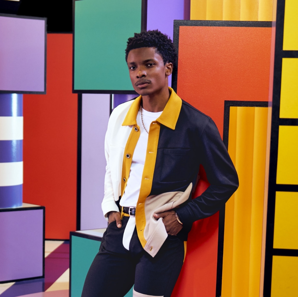 "Shoe Style Quiz: Choosing Shoes That Match Your Personality." The featured image is a model leaning against a multi-colored background in bold colors wearing a Stacy Adams shirt. 
