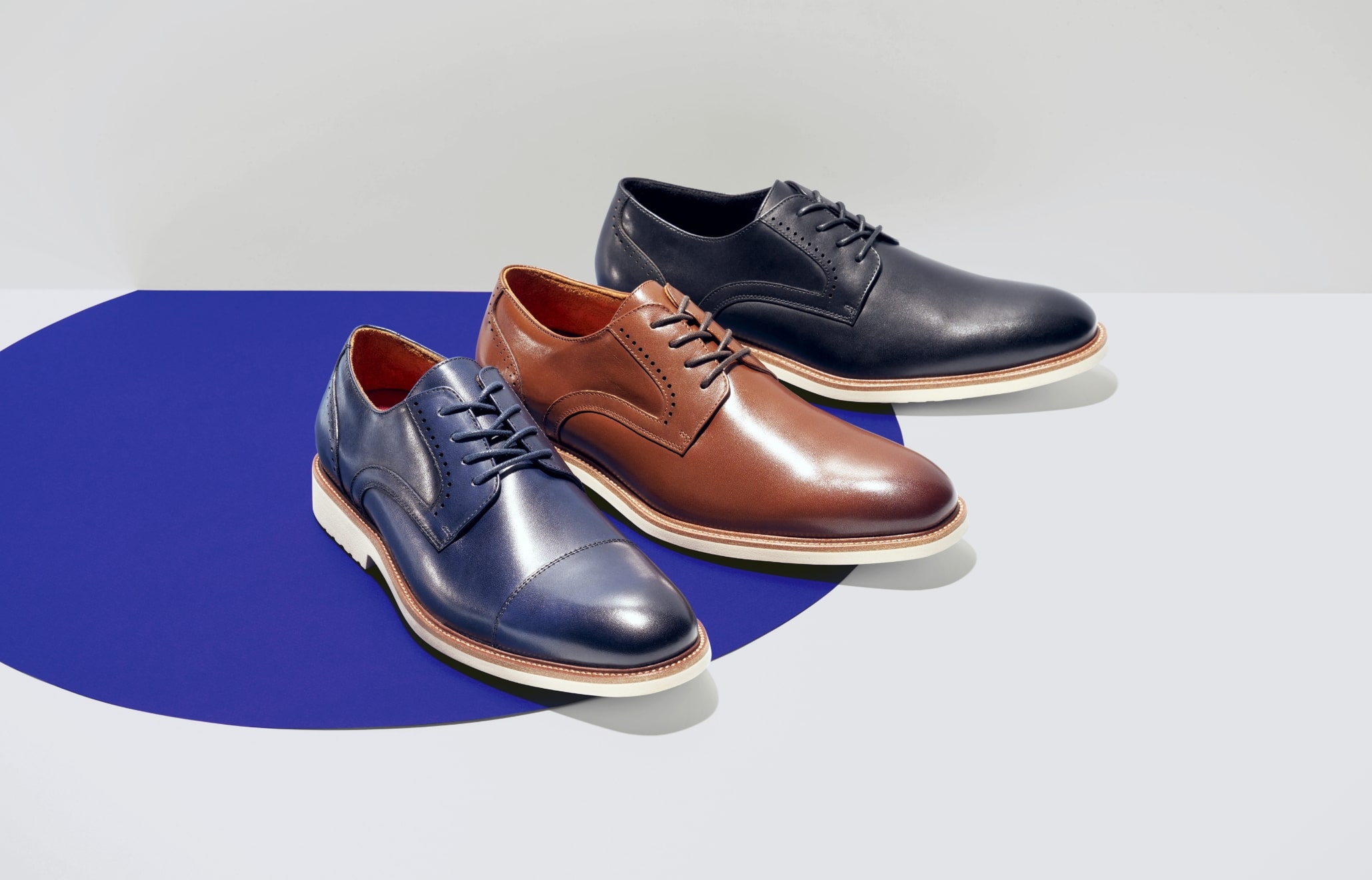 "Keeping Up With Men’s Fashion Trends As The Seasons Change." The featured image is of three Oxford shoes in black, cognac, and blue on a white and blue background.