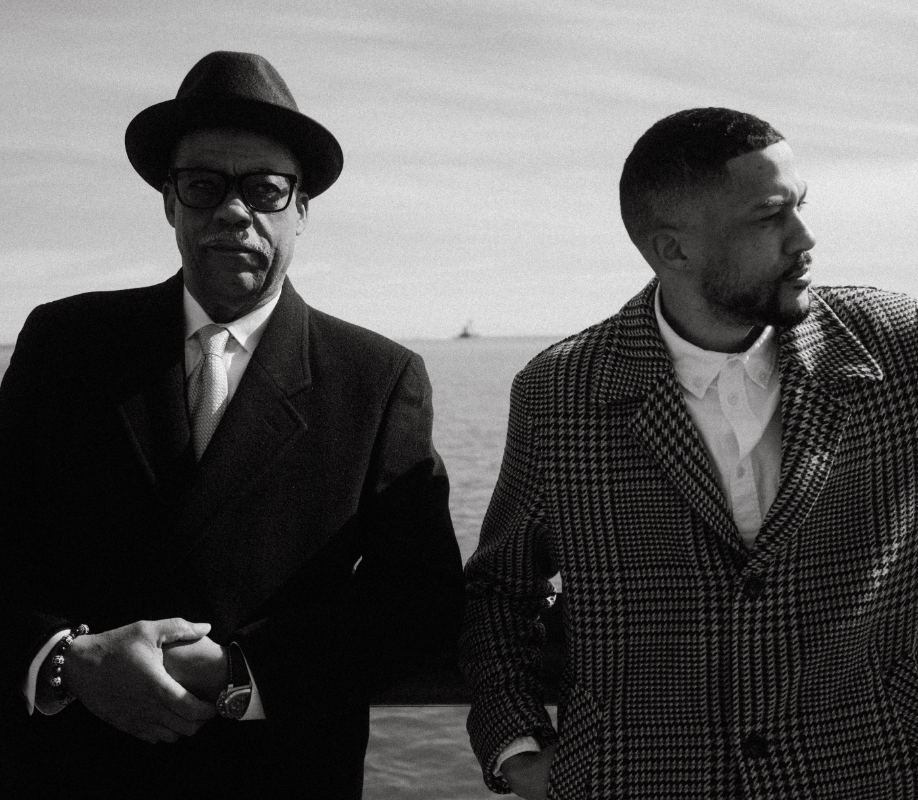"Generations of Style: A Stacy Adams Family Story." The featured black and white photograph is of Stacy Adams shoe designer Ryan Butts and his father, leaning against a railing in front of Lake Michigan in Milwaukee, WI. 