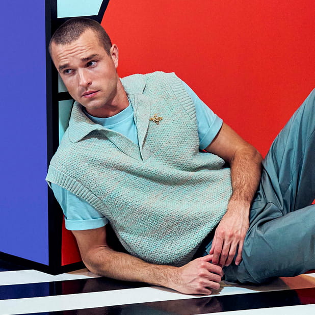 "A Guide To Business Casual Footwear." The featured image shows a model dressed in business casual attire resting against a geometric pattern background.