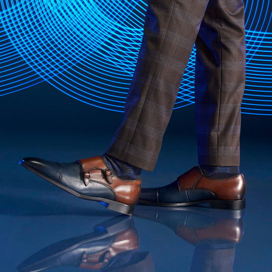 "Color Coordination For Clothes: Elevate Your Style With This Easy-To-Use Guide." The featured image is a man showcasing Stacy Adams double monk strap shoes in a blue room with blue lighting.