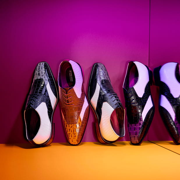 "Dress Code Explained: What To Wear To Parties And Events." The featured image shows four Stacy Adams cap toe oxfords standing vertically propped against a purple wall on a yellow floor.