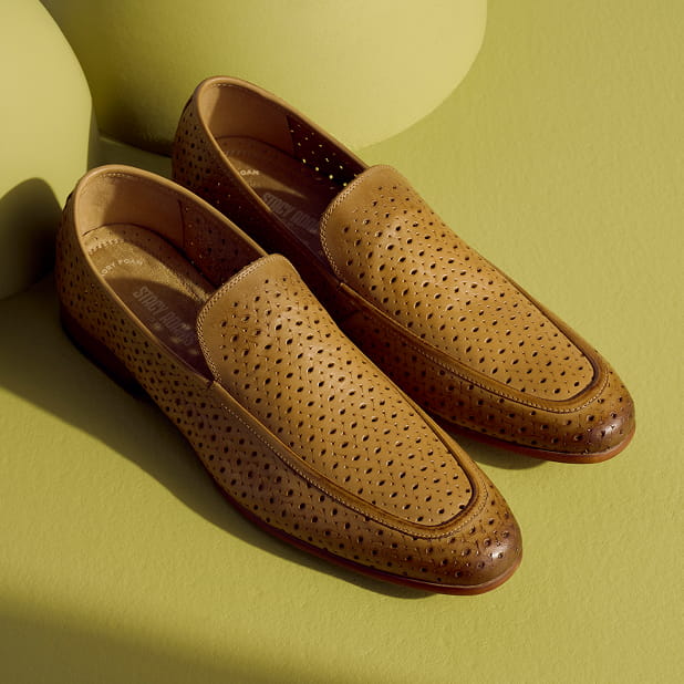"This Season’s Best Gift Ideas for Men." The featured product is the Stacy Adams Winden Moc Toe Perf Slip On in the color Natural against a green background.