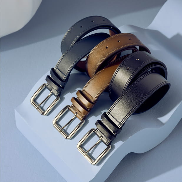 "Men’s Belts: The Perfect Finishing Touch." The featured product is the Stacy Adams Dylan Genuine Leather Belt shown in Navy, Brown, and Black.