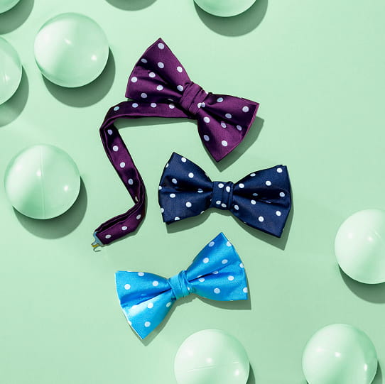 "Follow These Men's Style Tips For A Stylish Look From Head To Toe." The featured image shows three different colored polka-dot bow ties on a mint green background with bubbles.