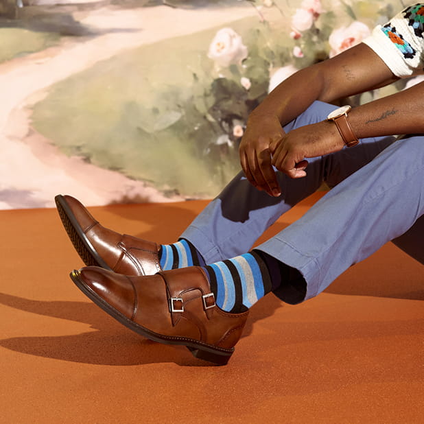 "Wide Shoes, the First Step to True Comfort." The featured image shows a model wearing blue striped socks and Stacy Adams Boswell Cap Toe Double Monk Strap in Brandy.