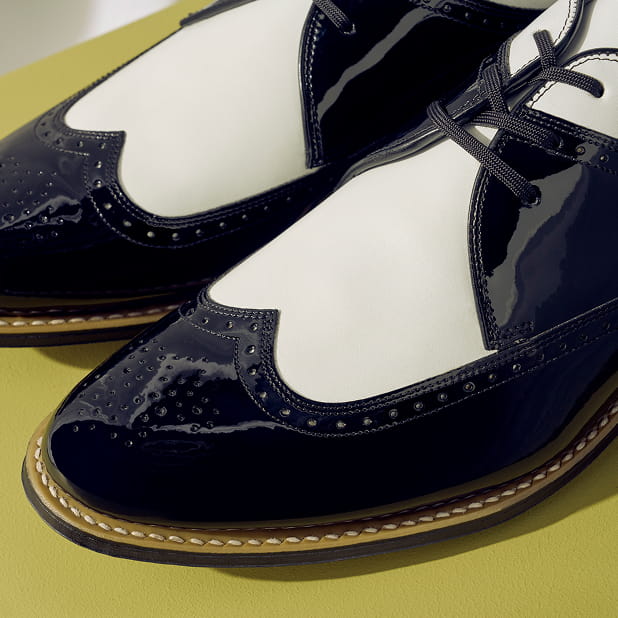 "Wingtip Shoes: A History." The featured image shows a close-up of the Stacy Adams Dayton Wingtip Oxford in Black w/White on a green background.