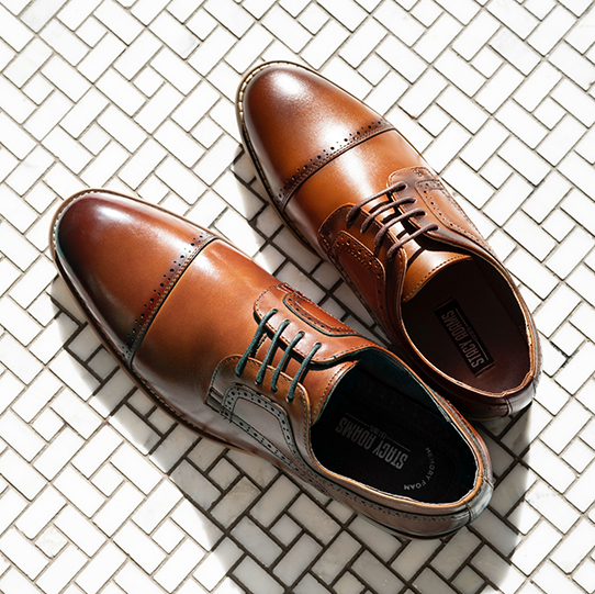 "In Search Of Versatile Men's Shoes? Our Dickinson Takes The Cake." The featured product is the Dickinson Cap Toe Oxford in Cognac.